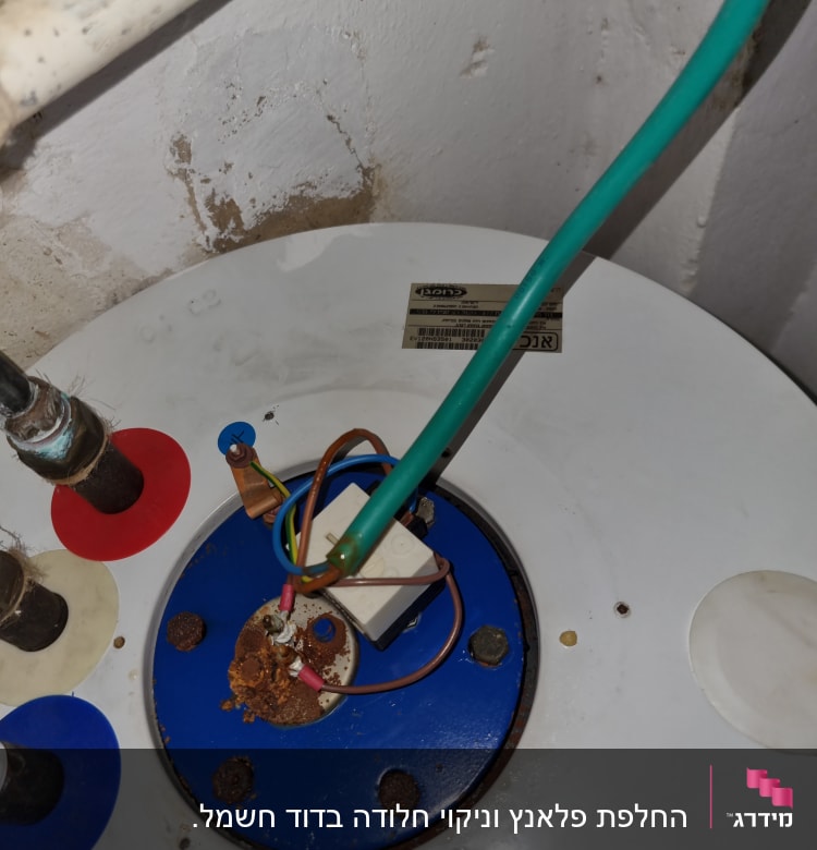 חוטי חשמל מחוברים לדוד חשמלי עם חלודה